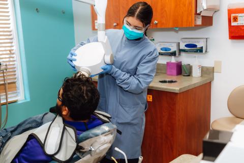 A student prepares a patient for dental x-rays.